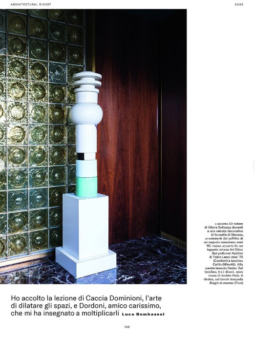 Decorative column against a wall with glass blocks and a wooden door.