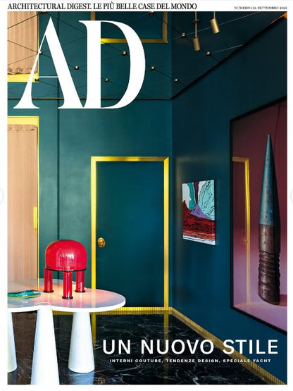 Cover of Architectural Digest magazine featuring a modern interior design with a red chair and teal walls.