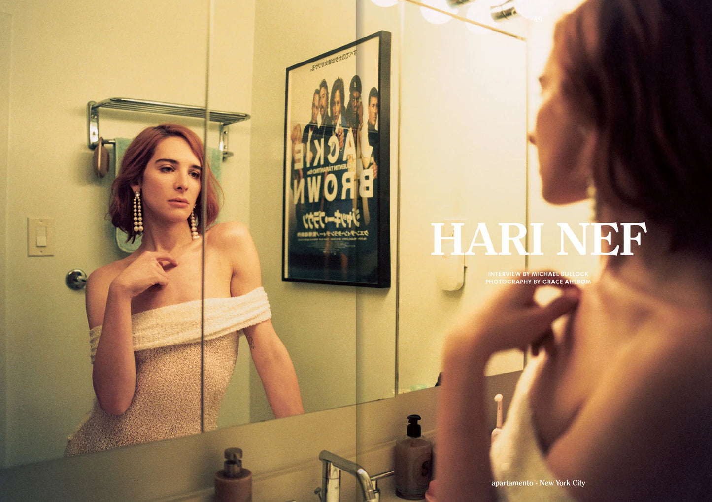 Hari Nef looking at herself in the mirror