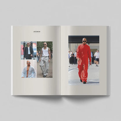 An open book or magazine spread photographed from above on a light gray background. The left page shows three small fashion photos with the caption 'LEWIS HAMILTON' at the top, and the right page shows a larger photo of a man wearing a bright orange outfit.