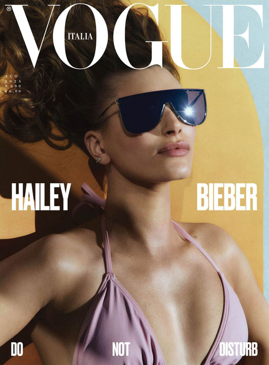 Vogue Italia magazine cover featuring Hailey Bieber wearing sunglasses and a swimsuit.