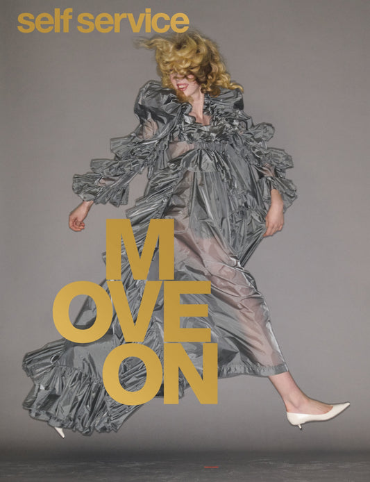 Woman on cover og magazine wearing grey gown with grey background